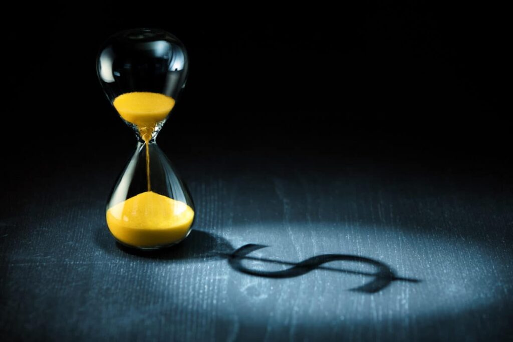 Start Investing by 35: Here’s What Time Could Do for Your Retirement Hourglass projecting a dollar sign as shadow